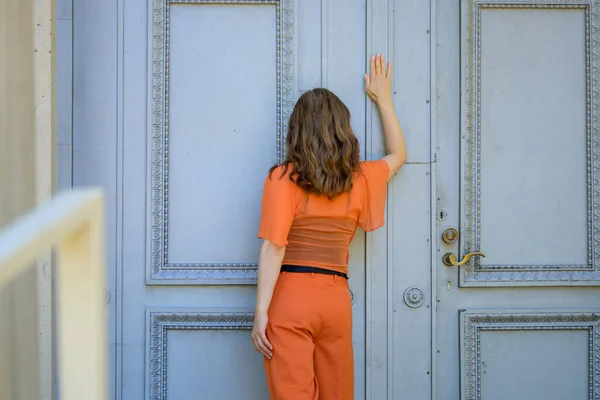 Rear View Woman Orange Knocking Historic Wooden Door Her Fist — Stock Photo, Image