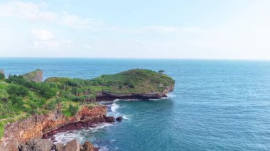 4K insansız hava aracı görüntüsü, yemyeşil uçurumları ve mavi okyanusla buluşan gizli bir kumsal görüntüsünü yakalıyor. Ses olmadan ultra kararlı bir hareketle çekiliyor. Sinema projeleri, seyahat videoları ve doğa geçmişi için ideal.