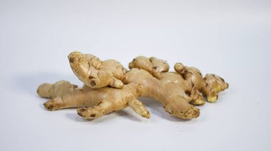 Beyaz arka planda izole edilmiş taze organik zencefil kökü doğal dokusunu ve şeklini gösteriyor. Mutfak tarifleri, sağlık ve sağlık içeriği, bitkisel ilaçlar, gıda ürünü reklamcılığı ve e-ticaret kullanımları için uygundur..