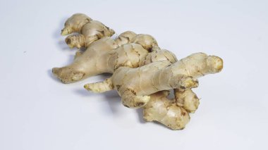 Temiz beyaz arka planda izole edilmiş taze zencefil kökü yakın plan. Doğal aromatik baharat yaygın olarak yemek pişirmede, bitkisel içeceklerde, geleneksel tıpta ve Asya mutfağında sağlıklı sağlık kavramlarında kullanılır..