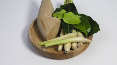 Taze limon otu sapları, galangal kökü ve beyaz stüdyo arka planında izole edilmiş ahşap bir tabakta kaffir limon yaprakları. Geleneksel Güneydoğu Asya aşçılık otları Tayland ve Endonezya mutfağında yaygın olarak kullanılır.