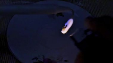 Karanlıkta sürekli yanan tek bir mum alevinin minimalist 4K görüntüsü. Siyah bir arkaplan karşısında sabit bir şekilde yanan statik çekim. Ses olmadan, sakinliği, umudu, meditasyonu, anıları ve kutsal atmosferi sembolize ediyor. Sinematik görseller ve anıtlar için uygun