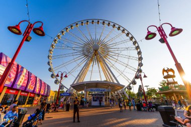 Niagara SkyWheel dönme dolabı Niagara Şelaleleri 'nin canlı Clifton Tepesi eğlence bölgesinin üzerinde turistik alanların keyfini çıkaran renkli eğlence merkezleri, dükkanlar ve ziyaretçilerle çevrilidir. Niagara Şelalesi, Kanada - 19 Eylül 2024.