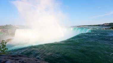 Yükselen siste gökkuşağı biçiminde Horseshoe Falls 'un kenarına akan güçlü suyun yakın görüntüsü. Niagara Nehri 'nin turkuaz suları Niagara Şelalesi, Ontario, Kanada' nın en ünlü doğal işaretlerinden birinde uçurumdan aşağı akıyor.