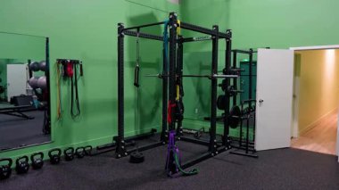 Rehabilitasyon ve işlevsel fitness egzersizleri için tasarlanmış gecekondular, direnç bantları, kettleçanlar ve aynalı duvarların yer aldığı modern bir fizyoterapi kliniği çalışma alanının iç görünümü. Burlington, Kanada - 22 Nisan 2025.