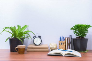 Kitaplar ve kırtasiye malzemeleri ofisteki masada.