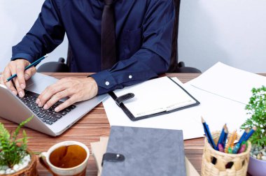 İş adamları masalarında çalışmak için dizüstü bilgisayar kullanırlar.