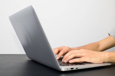 İnsan elleri masalarında dizüstü bilgisayar kullanıyor.