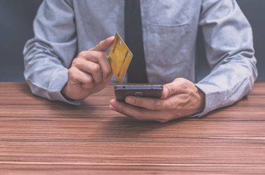 İş adamları akıllı telefonlardan online alışveriş yapmak için kredi kartı kullanıyorlar.