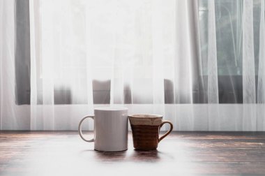 Masada bir bardak su ve bir kahve kupası var..