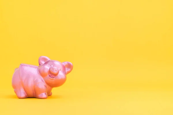 Piggy bank saving money against yellow background