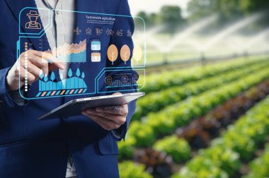 Sürdürülebilir tarım uygulamalarını geliştiren ileri teknolojiyi keşfedin. Bir çiftçi tarım verimliliğini optimize etmek ve ürün büyümesini izlemek için dijital araçlar kullanır.