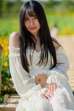 Güzel bir kadın, bahar boyunca canlı bir çiçek tarlasında zarifçe poz verir. Rengarenk çiçeklerin arasında zarafet ve neşe sergiler..