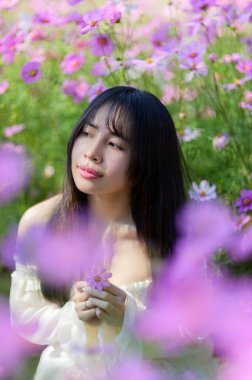 Güzel bir kadın, bahar aylarında canlı bir çiçek tarlasının ortasında durup neşe ve sükunet anları yakalıyor. Yumuşak ışık, onun huzurlu ifadesini güçlendiriyor, bir huzur hissi uyandırıyor ve doğayla bağlantı kuruyor..