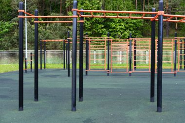 Yeşillik ile çevrili askeri eğitim sahasında, gençlik ve askeri personel için tasarlanmış spor aletleri, fitness ve yoldaşlığı teşvik etmek için