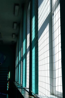 Güneş ışığı geniş pencerelerin arasından ağ örgüleriyle süzer, odayı aydınlatır ve güzel gölgeler bırakır, iç mekan ortamının huzurlu atmosferini arttırır.