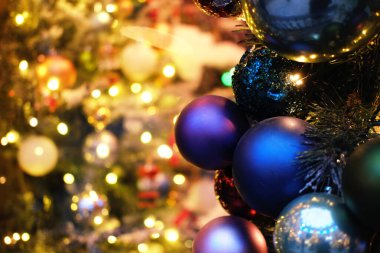 Canlı Noel süsleri, bereketli bir ağacı süslüyor, yumuşak ışıklarla aydınlatılıyor, şenlik ruhunu güçlendiriyor ve sıcak bir tatil ortamı yaratıyor.