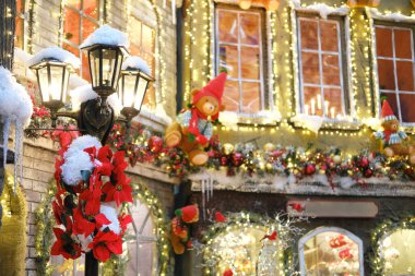 Canlı Noel süslemeleri bir alışveriş merkezinin dış görünüşünü güzelleştirir, renkli ışıklar, çelenkler ve eğlenceli süsler sergiler, bayram alışverişçilerini şenlik ruhunun tadını çıkarmaya davet eder.