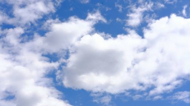 Geniş mavi gökyüzü yumuşak beyaz bulutlarla bezenmiş, huzurlu bir atmosferi çağrıştırıyor, doğa temalı tasarımlar veya arka planlar için mükemmel, sükunetin özünü yakalıyor.