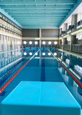 Açık mavi su ve kırmızı şeritli açık yüzme havuzu çocuk yüzme dersleri ve deniz eğlencesi için mükemmel bir ortam sağlıyor.