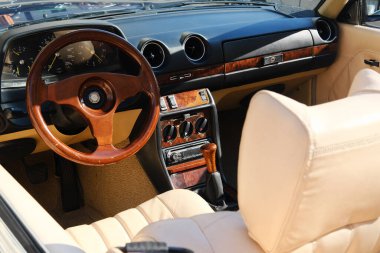 Minsk, Belarus - 10 Nisan 2025: Klasik araba iç mimarisi lüks deri koltuklar ve ahşap aksanlar sergiliyor, klasik otomotiv işçiliğinin zarafetini vurguluyor