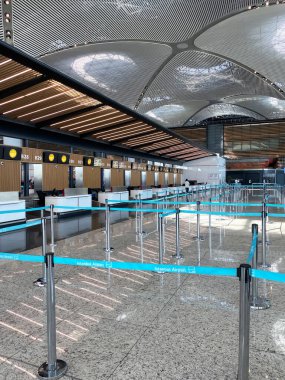 İstanbul, Türkiye - 09 Ocak 2025: İstanbul Havalimanı 'ndaki kuyruk engelleriyle dolu boş kontrol gişeleri, modern mimari ve geniş tasarım sergileniyor