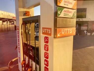 İstanbul, Türkiye - 20 Ekim 2025: Benzin istasyonunda farklı yakıt türleri ve hortumlar için açık tabelalı markalaşma ve güvenlik talimatları içeren yakıt dağıtıcısı