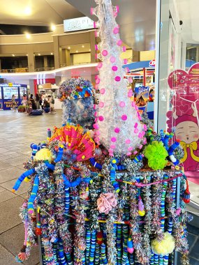 Phuket, Tayland - 29 Ekim 2025: Geri dönüşümlü plastik malzemelerden yapılan renkli heykel, çeşitli dekoratif unsurlarla bir alışveriş alanında sergileniyor.