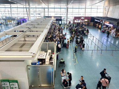 Phuket, Tayland - 01 Kasım 2025: Phuket Havalimanı 'nın kalkış alanı, arka plandaki dükkanlar ve oturma alanlarıyla kontrol gişelerinde kuyrukta olan yolcuları gösteriyor
