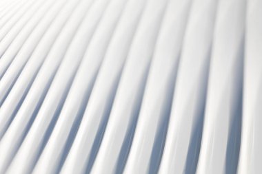 Pürüzsüz, kıvrımlı kaburga çizgileri ve minimalist geometri içeren soyut ikm beyaz mimari deseni. Yumuşak ışık ve gölgeli modern fütürist arkaplan, vurgulu doku, akış ve zarif tasarım.