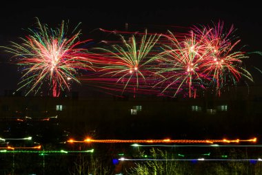Noel ve yeni yıl havai fişekleri. Bir gece şehrinin arka planına karşı. Şenlikli atmosfer.