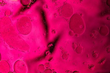 Vivid pink liquid surface with smooth organic patterns, bold creative background.