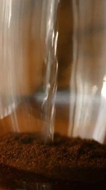 Kremalı sıcak kahvenin yavaş çekimde yakın plan çekimi düzgün bir girdap oluşturur. Sıcak içecek ve sabah rutin konsepti.