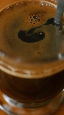 Yakın çekim makro, taze demlenmiş espresso ve krema karışımı. Kahve hazırlama süreci, aromatik sıcak içecek konsepti..