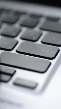 Gümüş bir klavyede Enter tuşuna basmak. Son derece yakın çekim. Dikey video.