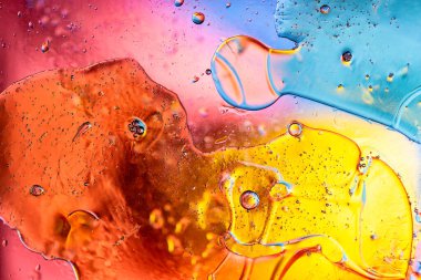 Parlak ve enerjik sarı ve turuncu makro fotoğraf petrol baloncukları güneşli bir yaz atmosferi yaratıyor.