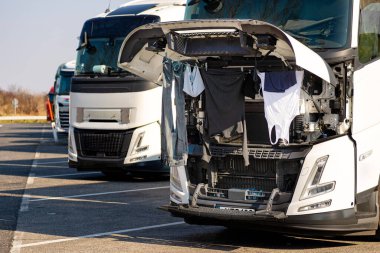 Büyük bir kamyonun kaputunun altında kurumuş giysiler. Araba park halinde. Şoförün günlük ihtiyaçları..