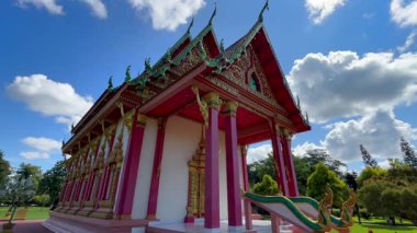 Namsai, Arunachal Pradesh, Hindistan 17 Şubat 2026: Güzel dekore edilmiş bir Budist tapınağı dağınık bulutlu parlak mavi bir gökyüzünün altında duruyor. Yapıda kırmızı sütunlar, altın oymalar ve karmaşık bir şekilde tasarlanmış çatı ayrıntıları yer alıyor..