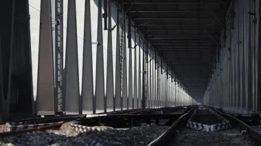 Dibrugarh, Assam, Hindistan, 12 Mart 2026: Köprü içinde güçlü bir perspektif oluşturan uzun çelik köprü yapısı boyunca uzanan demiryolu rayları.