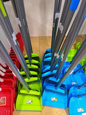 Kırmızı, yeşil ve mavi renkli süpürgeler ve süpürgeler de dahil olmak üzere yeni yer temizleme araçları birlikte sergilenmektedir. Perakende ortamda kullanılmayan koşullarda gösterilen, yerleri temizlemek için ev aletleri.