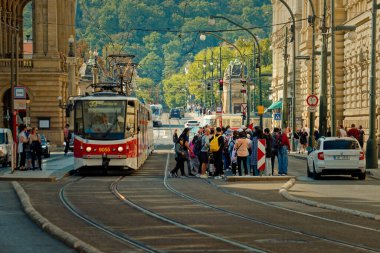Meşgul Şehir Tramvayı Bekleyen Yolcularla Kalabalık Durağı 'na yaklaşıyor, Tarihi Taş Binalar,