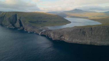 Dik uçurumların çerçevelediği Havadan Kıvrımlı Göl Gölü Kıyı Adaları Yumuşak Işık, Sükunet