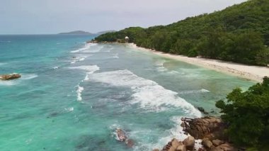 Seyşeller Kıyısı açıklarındaki Hava Turkuaz Deniz Burnu. İnsansız hava aracı mercan düzlüklerinde ve beyaz kumsalda süzülüyor.