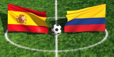 İspanya ve Kolombiya bayrakları arasına yeşil çimen spor sahasında bir futbol topu konur.