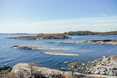 Gündüz vakti güneş ışığı altında mavi derin göl manzarası, gökyüzünde bulutlar Ladoga skerries Karelia