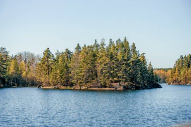 Gündüz vakti güneş ışığı altında mavi derin göl manzarası, gökyüzünde bulutlar Ladoga skerries Karelia