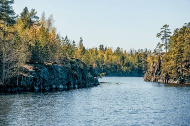 Gündüz vakti güneş ışığı altında mavi derin göl manzarası, gökyüzünde bulutlar Ladoga skerries Karelia