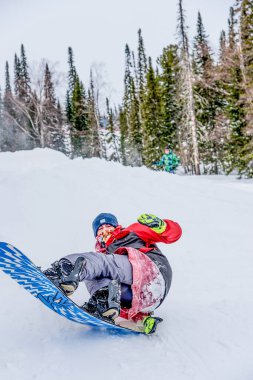 Sheregesh, Sibirya, 6 Ocak 2018, Snowboardcu kayakçı kayak pistinde kayıyor, kayak merkezinde dinleniyor, ekstrem sporlar yapıyor.
