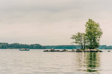 Turistler, Karelia 'da bulutlu bir yaz gününde Ladoga Gölü' nde ahşap teknelerde yelken açarlar.