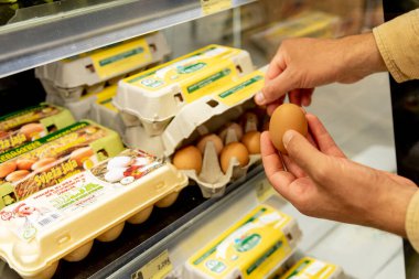 Bar, Karadağ, 17 Mayıs 2025, İnsan süpermarkette tavuk yumurtalı konteynırı seçti